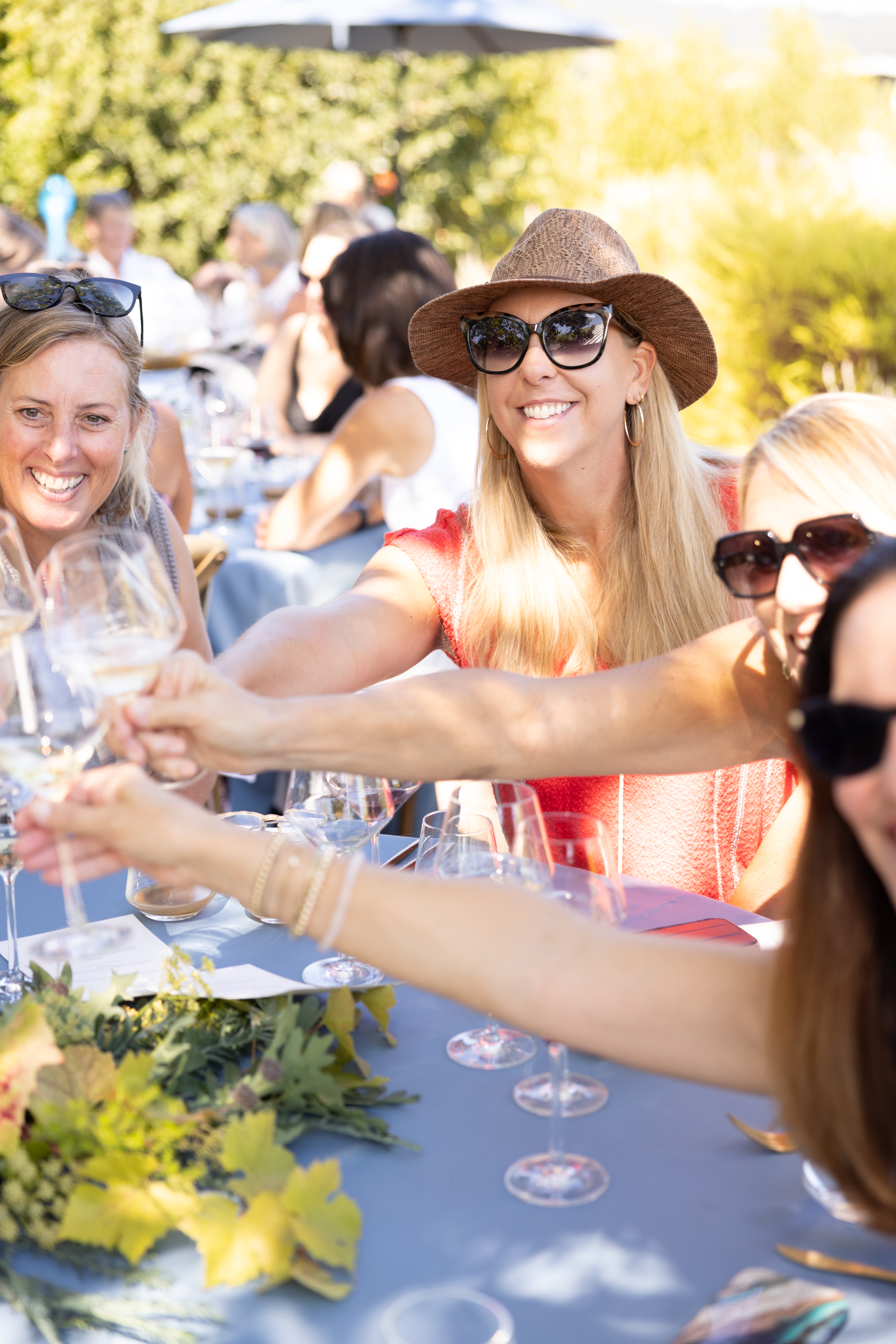 People smiling and cheersing with wine glasses