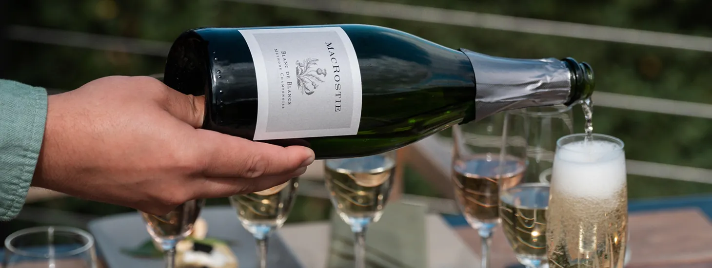 Bottle of MacRostie sparkling wine being poured into wine glasses