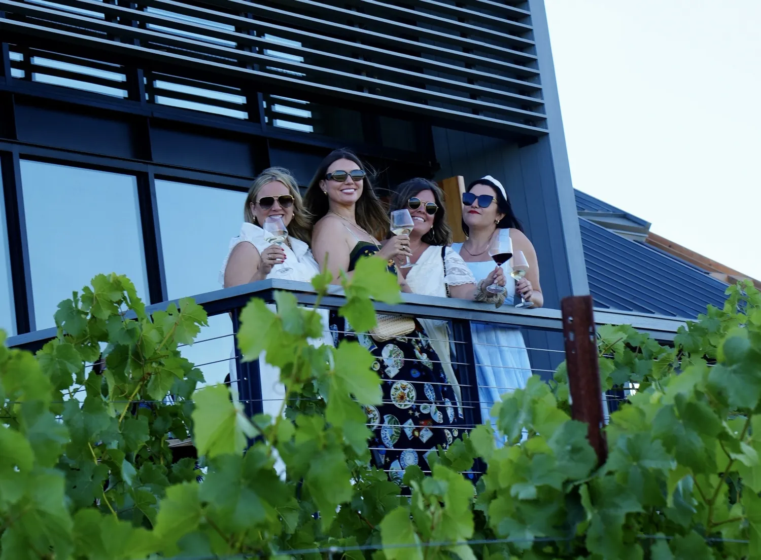 People holding wine glasses outside the MacRostie Estate House