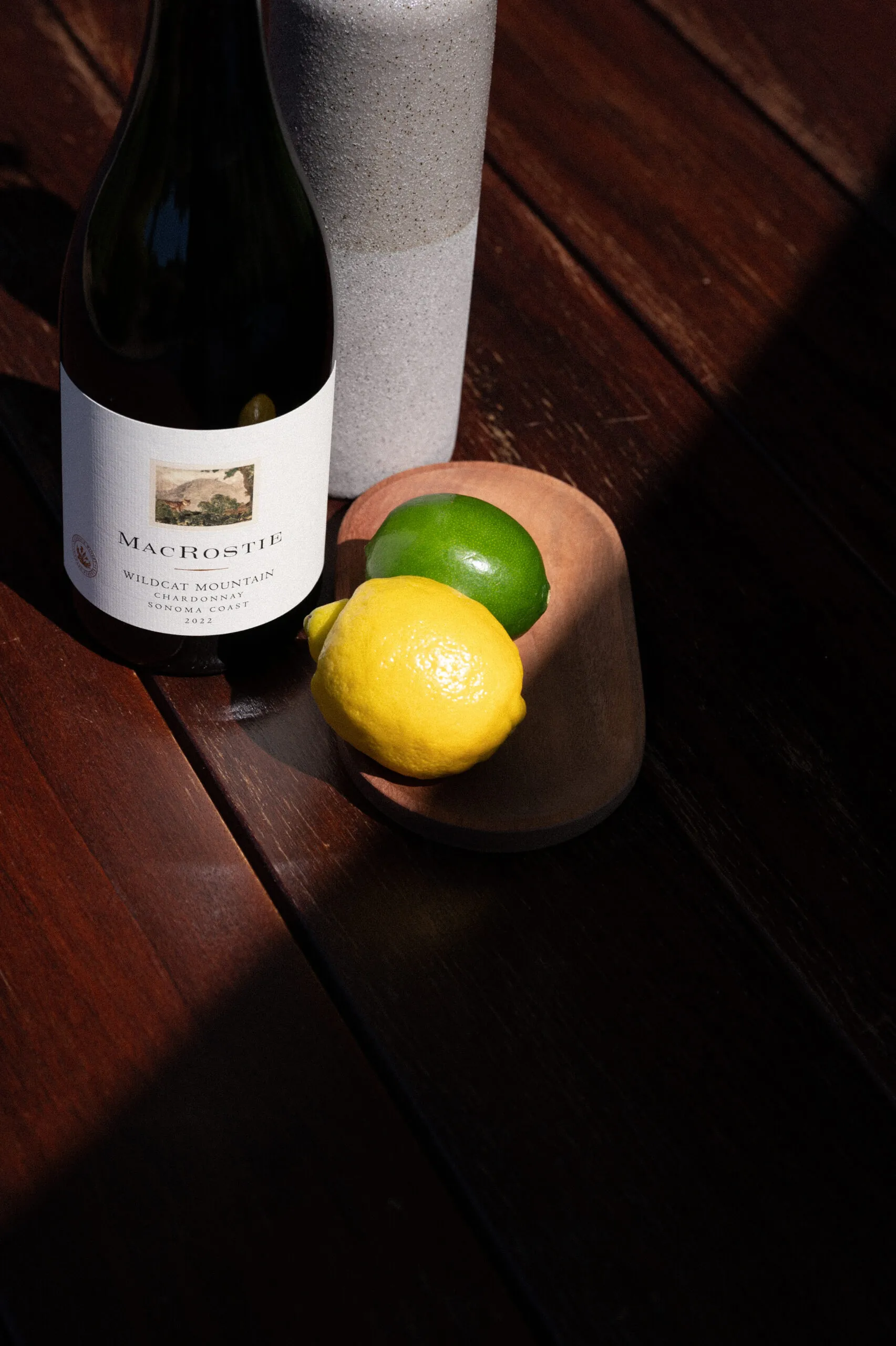 Bottle of MacRostie wine next to a lemon and lime