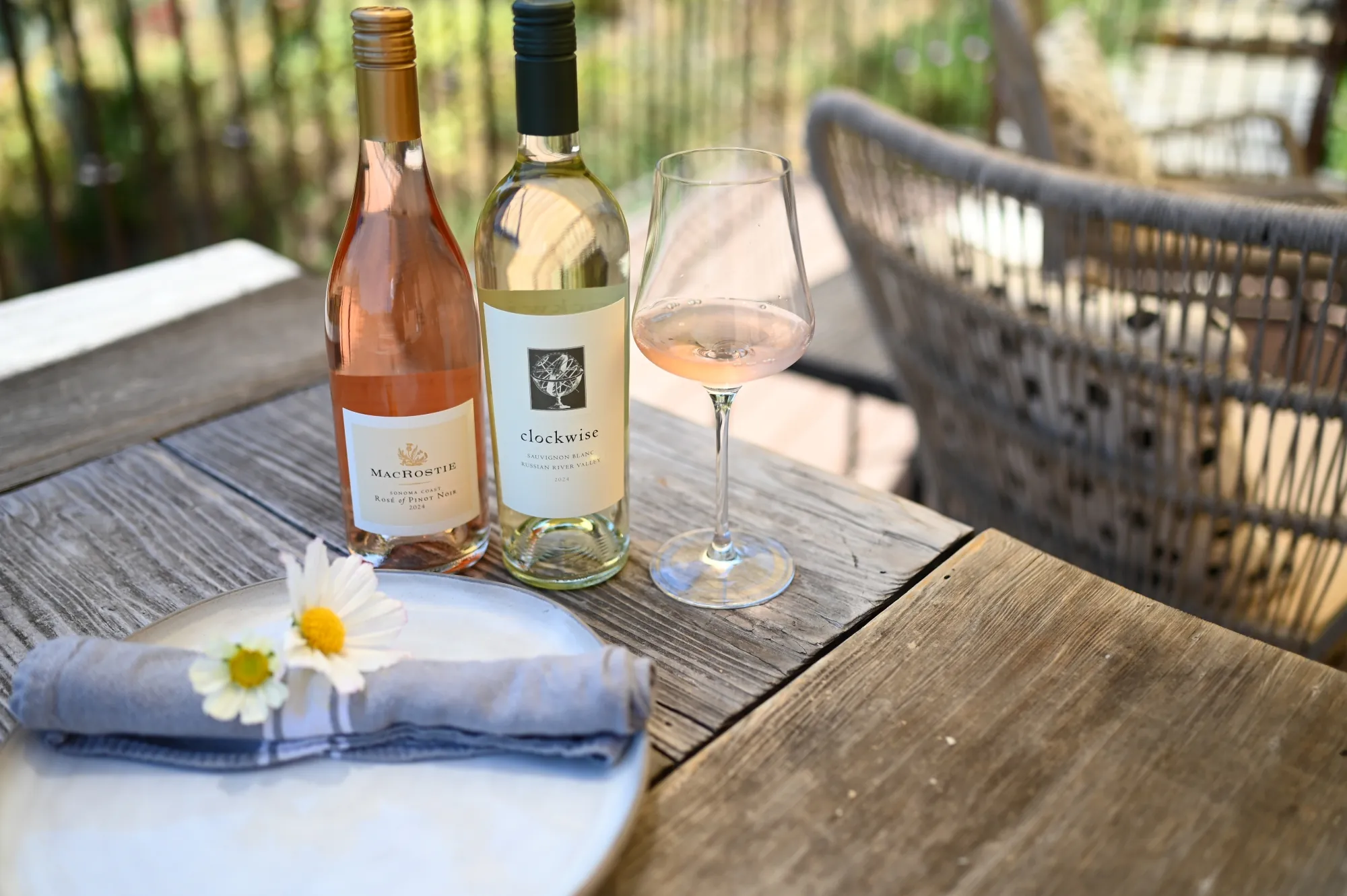 MacRostie wines next to a plate with flowers on top and a glass of wine.