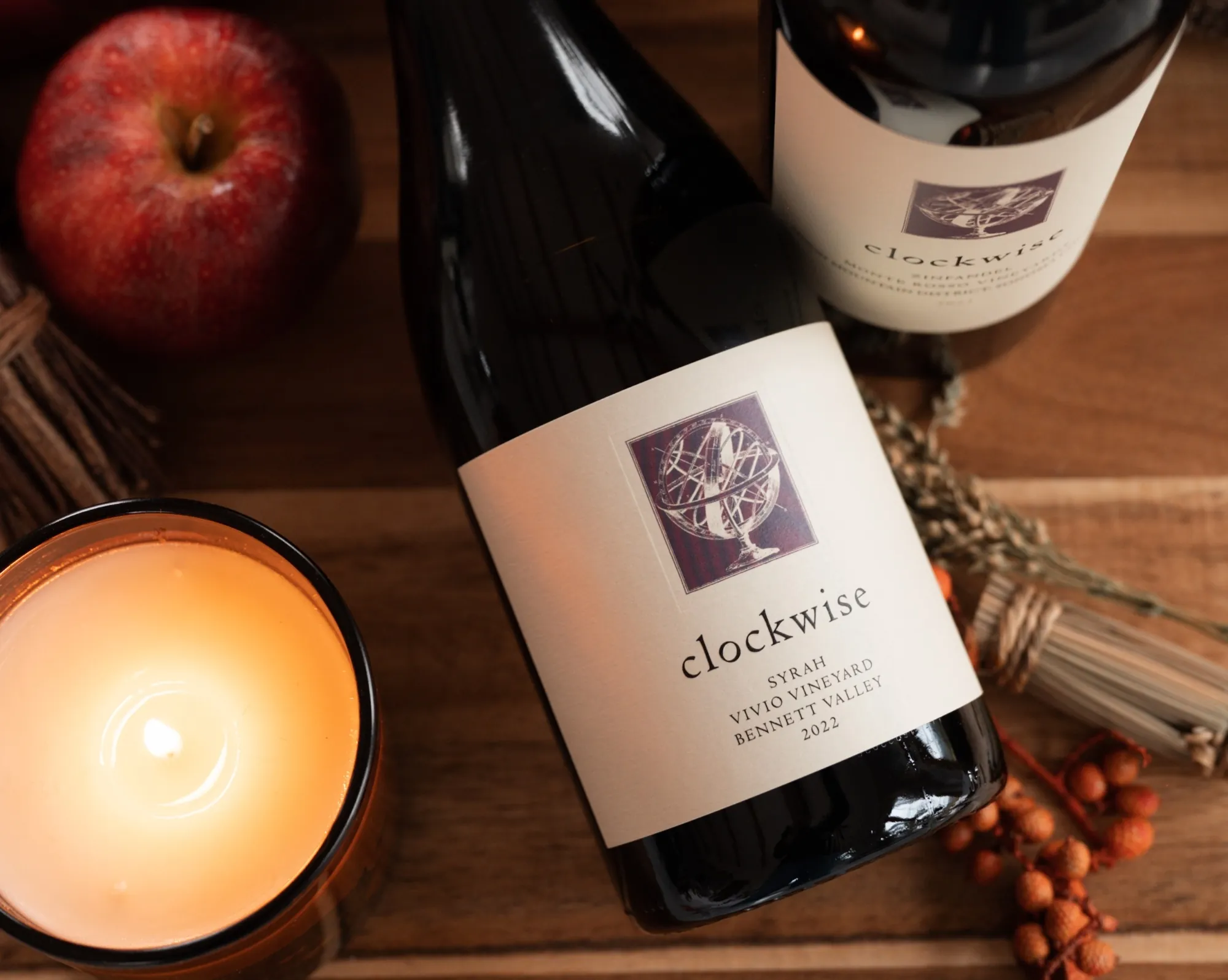 Two bottles of Clockwise wines on a table next to fall decorations