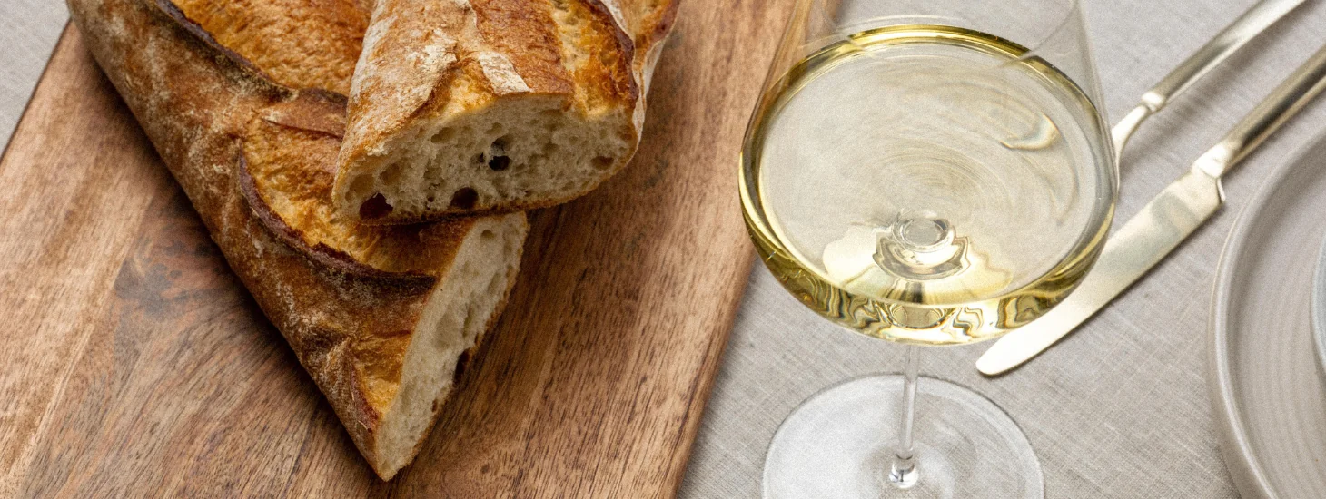 Glass of wine next to a loaf of bread