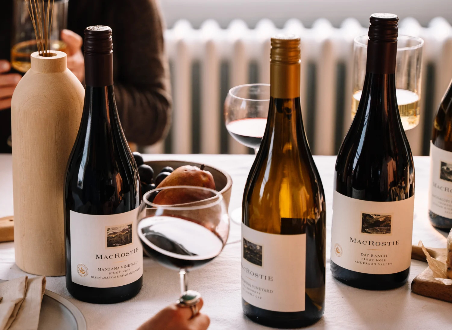 Bottles of MacRostie wine and wine glasses on a dinner table
