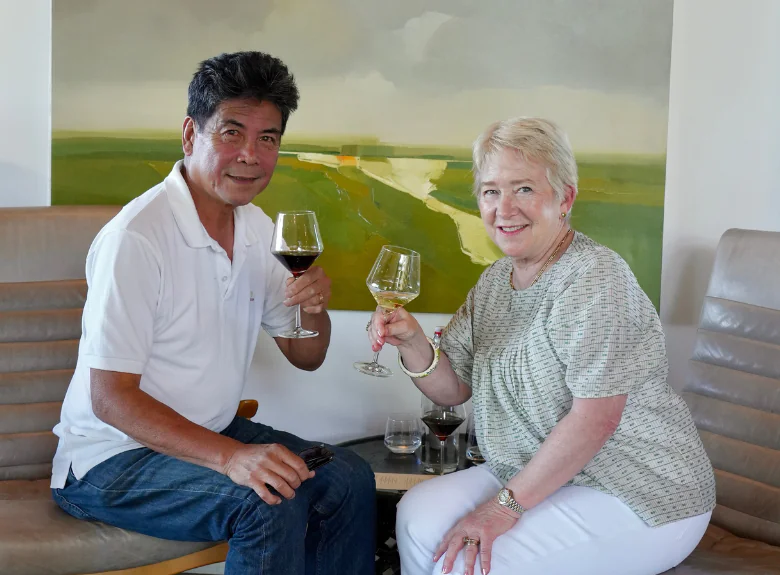 Couple raising wine glasses at a table in the MacRostie Estate House