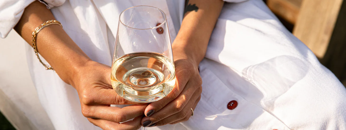 Hands holding a glass of wine